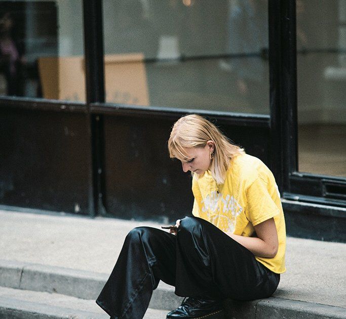 可愛らしいレモン色のTシャツを、黒パンツと無骨なブーツでクールに