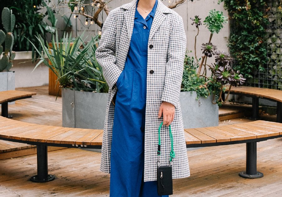 あざやかなブルーのジャンプスーツを主役に、チェックコートをあわせて