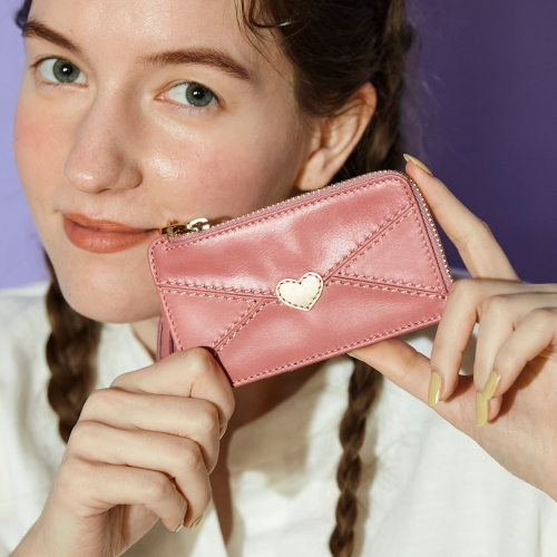 ピンク色の財布を手にもつ女性