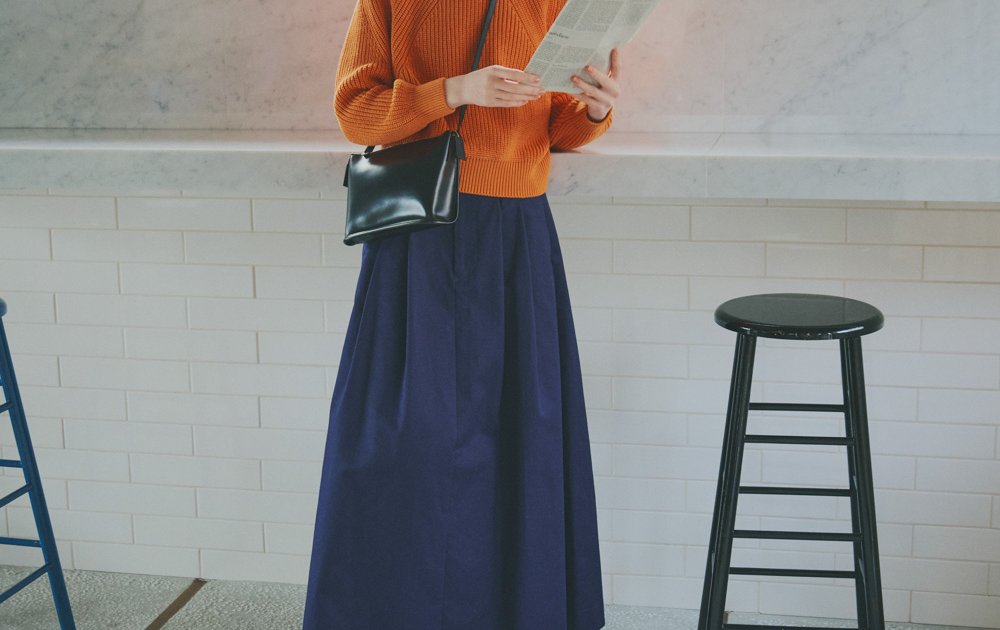 ネイビースカート×オレンジニットで爽快な大人カジュアルを完成させる